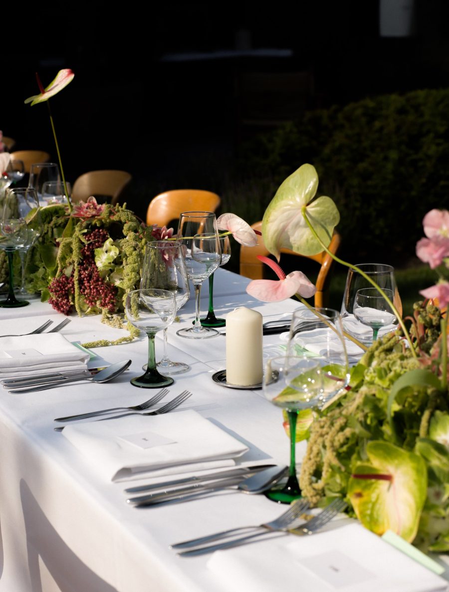 Wedding table with green-stemmed glasses and anthurium flowers
